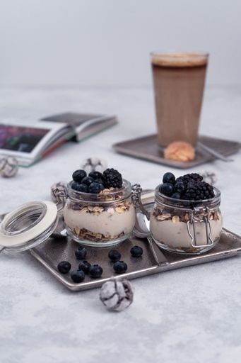 A vertical shot of yogurt with blueberries in a jar