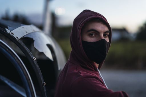 A closeup shot of a young man posing wearing a sanitary mask - concept of the new normal