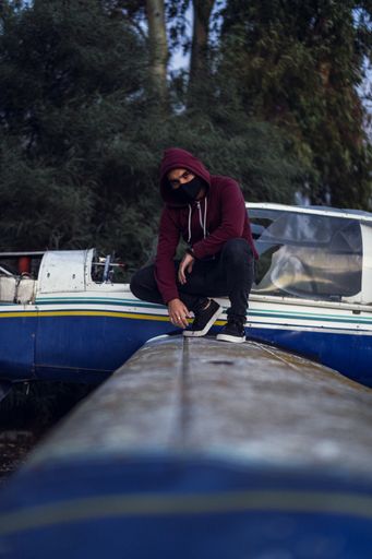 A vertical shot of a cool young man posing wearing a sanitary mask - concept of the new normal