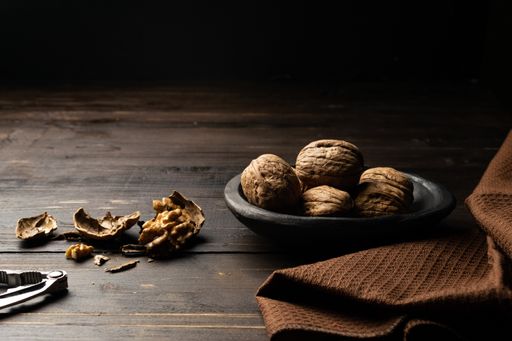 A nutcracker and cracked walnuts on a wooden table