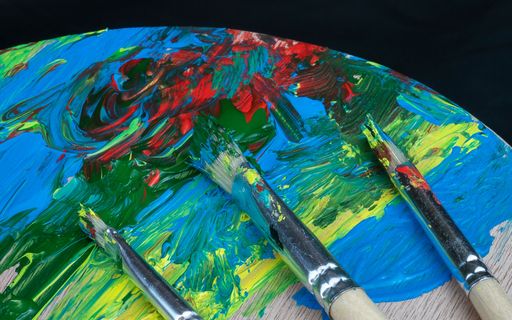 A vertical shot of a oil paint swiped on a canvas with brushes on a black background