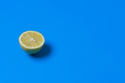 A split juicy lemon on blue background with an empty space for a text