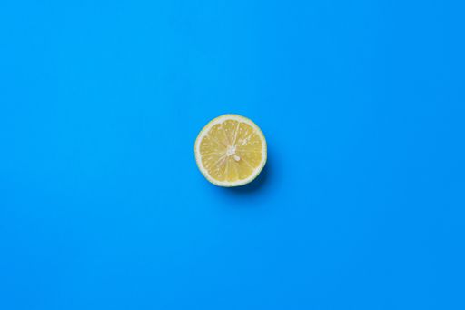 A top view of a split juicy lemon on blue background with an empty space for a text