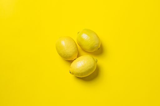 A top view of lemons on yellow background with an empty space for a text