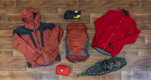 A high angle shot of mountain climbing clothes and equipment on a wooden surface