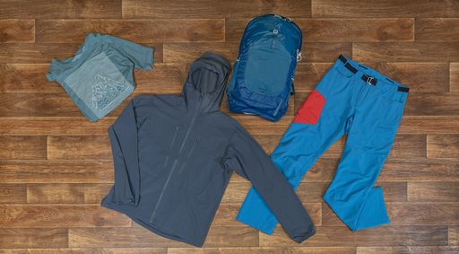 A high angle shot of mountain climbing clothes and equipment on a wooden surface
