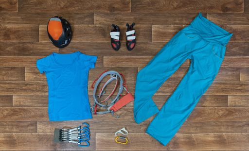 A high angle shot of mountain climbing clothes and equipment on a wooden surface