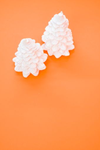 A vertical shot of Christmas ornaments on an orange surface