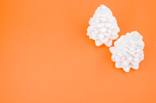 A high angle shot of Christmas ornaments on an orange surface