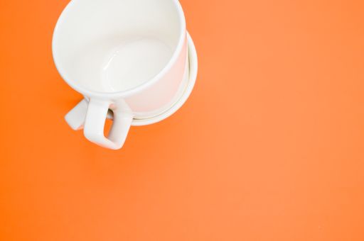 A high angle shot of two empty cups on an orange surface