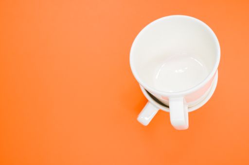 A high angle shot of two empty cups on an orange surface