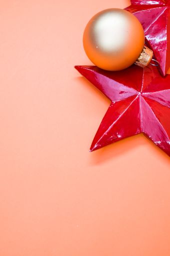 A vertical shot of Christmas ornaments on an orange surface