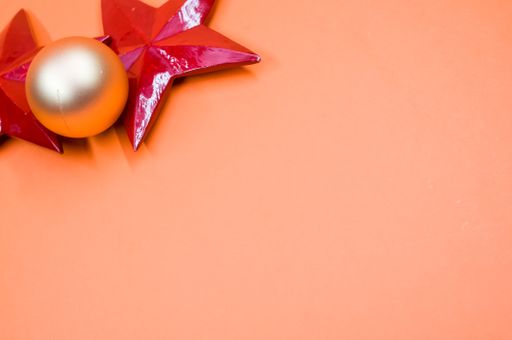 A high angle shot of Christmas ornaments on an orange surface