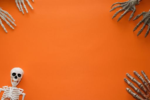 An orange background for Halloween with skeletons and a copy space