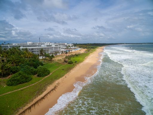 A beautiful shot of the calm ocean waves moving towards the sandy shore in Sri Lanka