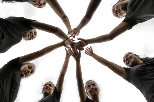 A confident all-female soccer team huddle before a soccer game