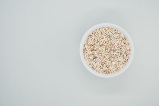 A high angle shot of a bowl of cornflakes on a white surface
