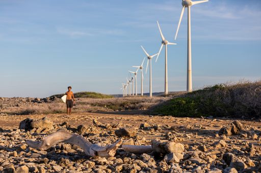 A male surfer walking to the ocean getting ready for extreme fun in Bonaire, Caribbean