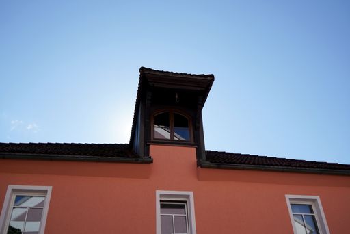 A low angle shot of a house roof against a clear blue sky