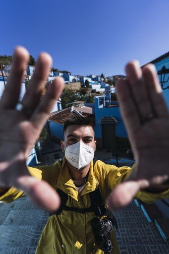 A vertical shot of a young man posing wearing a sanitary mask-concept of the new normal