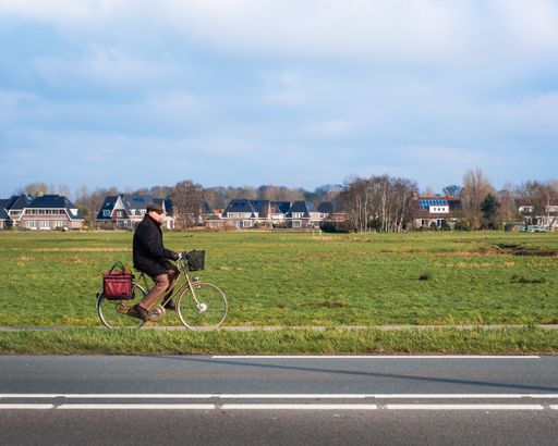Gentleman riding a bike near road in countryside