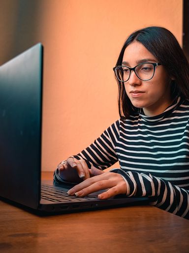 A young teenager female studying on her laptop