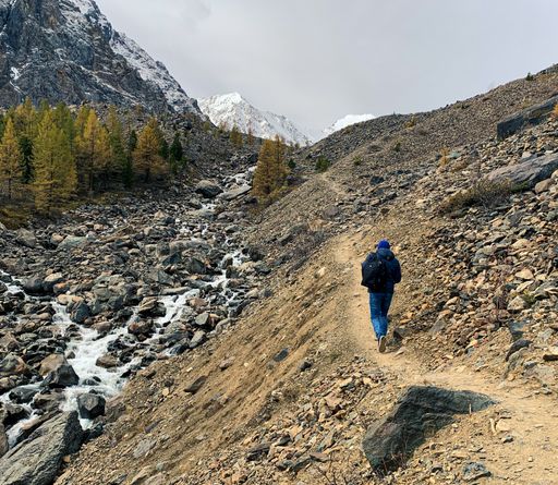 A back view of a hiker walking through rocky mountains