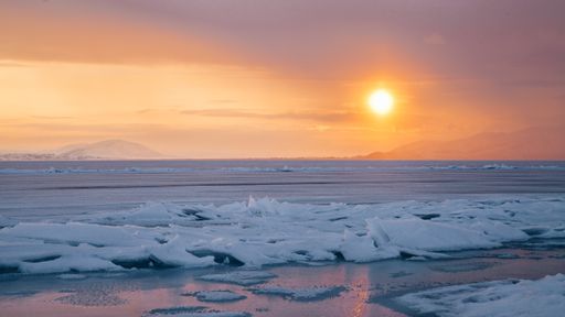 A beautiful view of frozen Lake Sevan on a winter day during the orange sunset