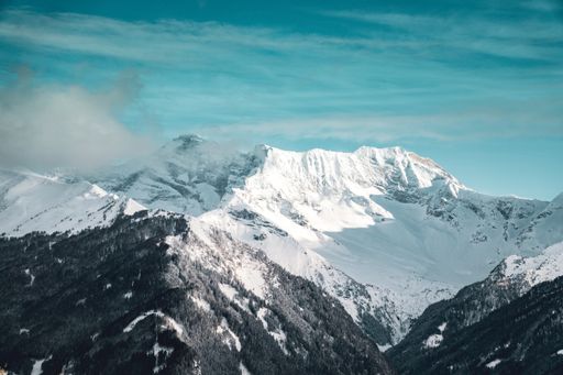 A wide shot of the beautiful snow covered mountains under the cloudy sky