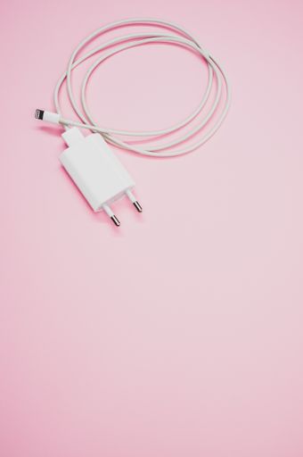 A white USB compact charger with cable