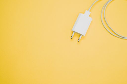 A white USB compact charger with cable