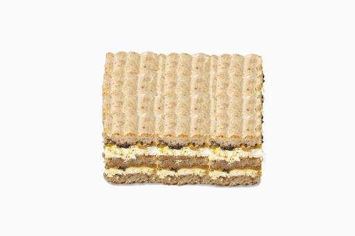 A square slice of a cake with cream and chocolate filling isolated on white background