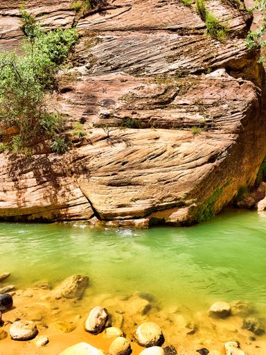 A vertical shot of a rock near a stream