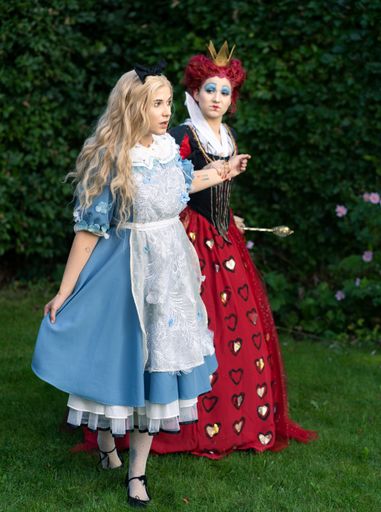 Cosplayer as characters from Alice in Wonderland. Alice is held and controlled by the red queen