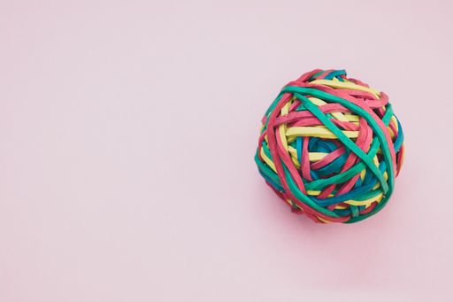 A top view of a rubber ball made out of rubber bands isolated on a purple background