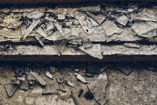 A high angle shot of shattered glass scattered over the old wooden stair