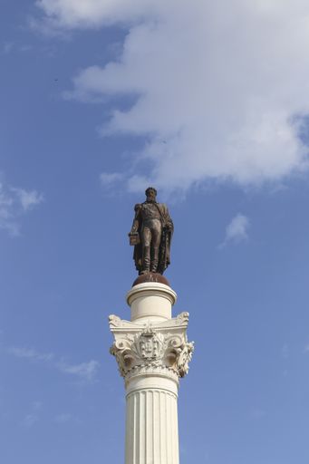 A vertical shot of the Column of Pedro IV monument in Lisbon, Portugal against a cloudy blue sky