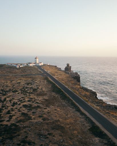 A vertical shot of a beautiful seaside view with the Cabo da Roca Lighthouse in the distance, in Peniche, Portugal