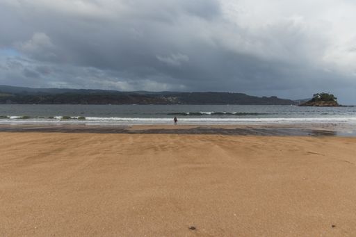 A landscape of a beach surrounded by the sea under a cloudy sky during a gloomy day in Viveiro, Spain