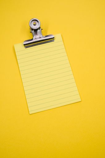 A vertical shot of a notepad with a paper clipper isolated on a yellow background