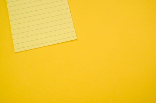 A top view of a blank notepad isolated on a yellow background