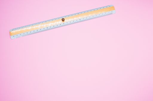 A top view of a colorful ruler isolated on a pink background