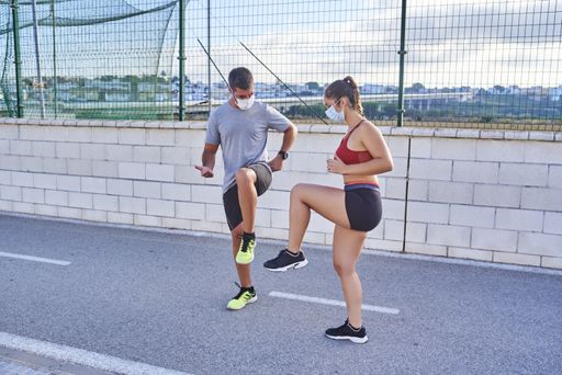 A young Caucasian sporty couple training together outside during Covid-19