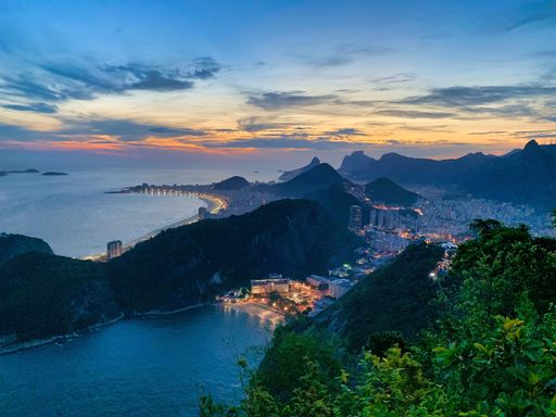 An aerial shot of Copacabana beach near an illuminated cityscape in Rio de Janeiro, Brazil