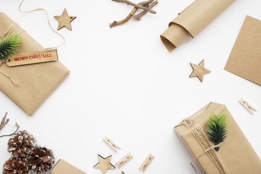 A top view of wrapped gifts, fig branches, pine cones, Merry Christmas tag with copy space isolated on a white background