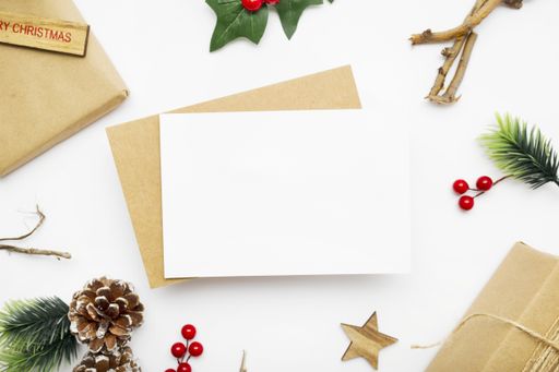 A top view of wrapped gifts, holly berry plant, fir branches, and pine cones for Christmas with copy space isolated on a white background