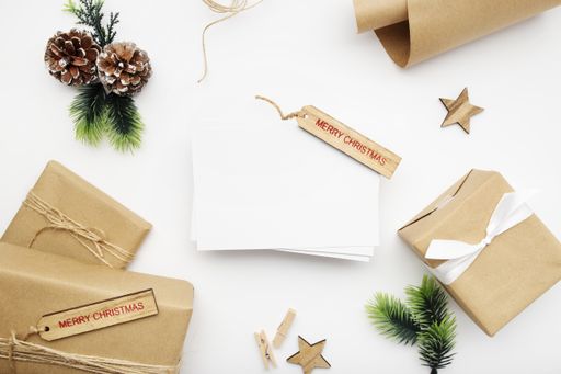 A top view of wrapped gifts, fir branches, pine cones, and Merry Christmas tag with copy space isolated on a white background