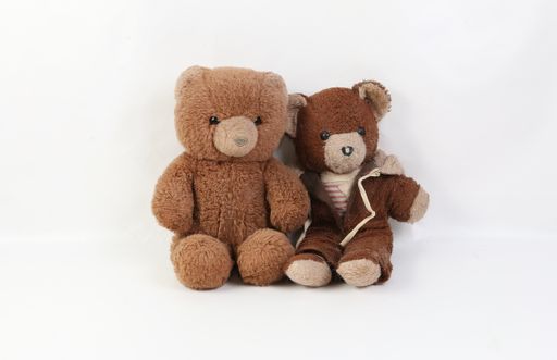 Two old brown damaged teddy bears isolated on a white background