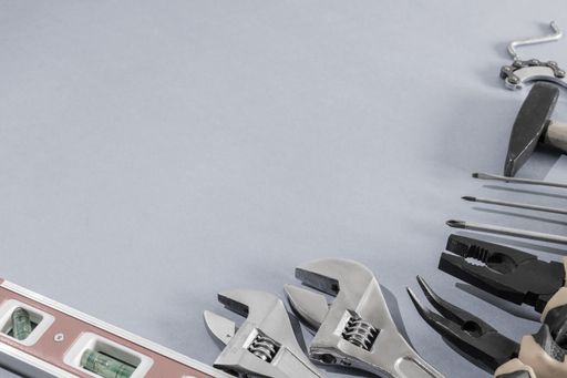 A top view of pliers and adjustable wrench on a gray background