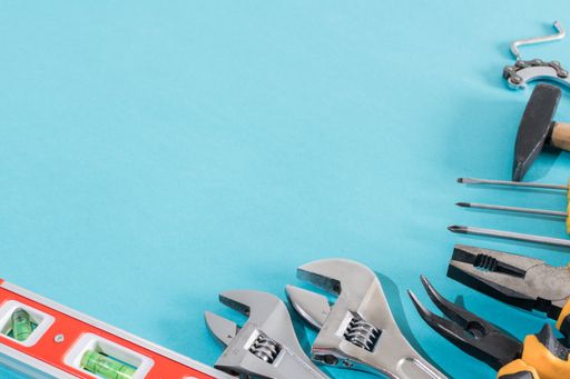 A top view of pliers and adjustable wrench on light blue background